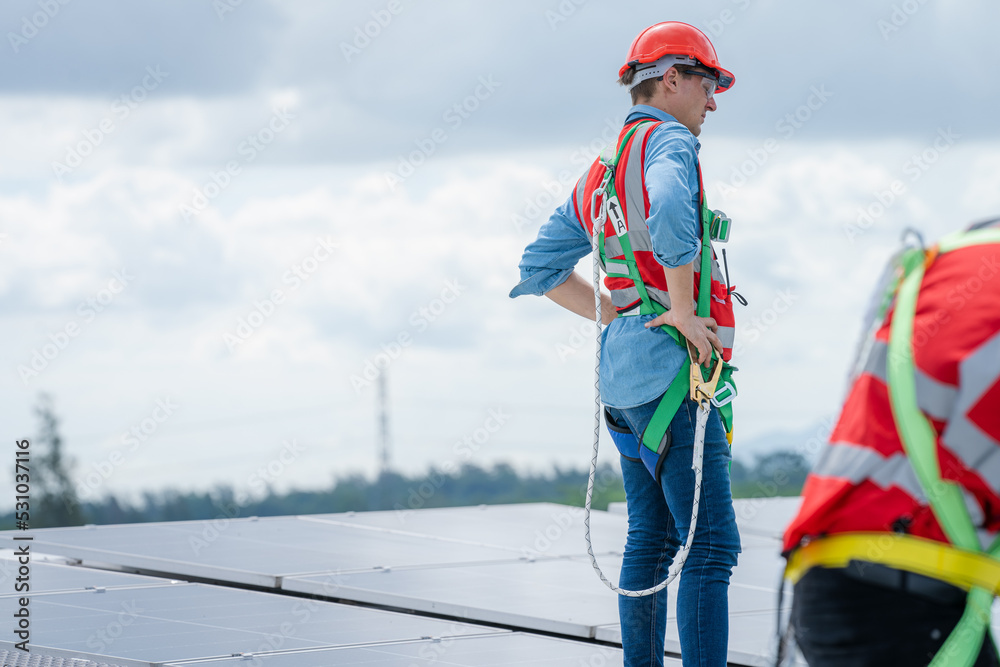Poster Professional worker installing and checking solar panels on the roof of a factory,Innovative solution for energy solving. Use renewable resources. Green energy.