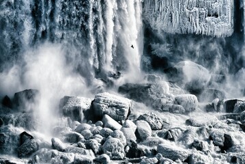 Dramatic greyscale shot of waterfalls splashing to the rocks - obrazy, fototapety, plakaty