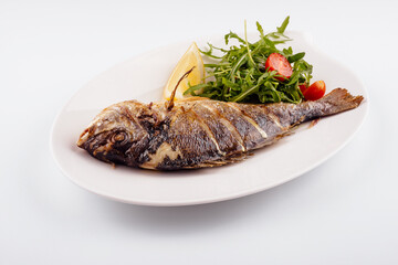Baked sea bream fish with arugula salad and tomatoes