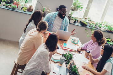 Photo of happy smiling businesspeople listening training coach writing noted indoors workplace workshop loft