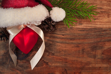 Obraz na płótnie Canvas Santa hat with Christmas ball in the form of heart