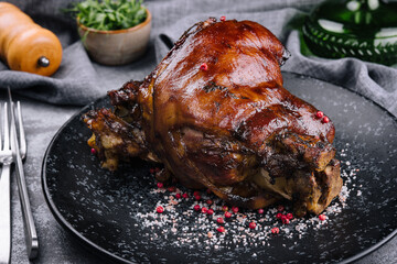 Roast pork knuckle on black plate