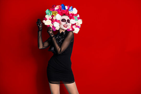 Photo of creepy monster zombie lady dreamy dance latin vibes pretend have maracas give rythm wear black short mini dress death costume roses headband isolated red color background