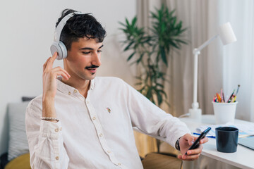 young adult man having video call using mobile phone from his home
