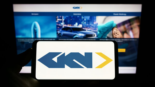 Stuttgart, Germany - 09-10-2022: Person holding smartphone with logo of aerospace and automotive comopany GKN Ltd. on screen in front of website. Focus on phone display.