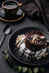 Plate with fresh brownies and ice-cream on black plate