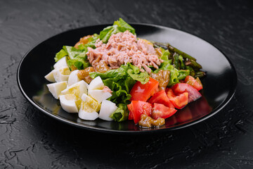 Tuna and vegetable salad on black plate