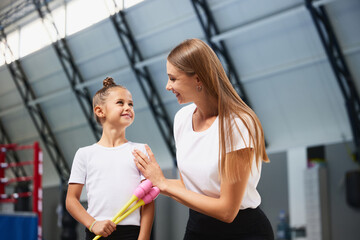 Coaching and support. Sport coach compliments beginner gymnastics athlete with first victory....
