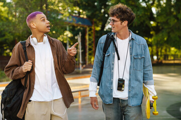 Two young handsome smiling stylish boys talking to each other