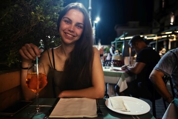 Happy woman sitting at table and enjoying drink