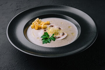 Creamy mushroom soup with champignons on black