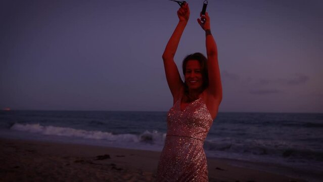 Attractive woman fire dancer spinning flames at the beach. Slow Motion.