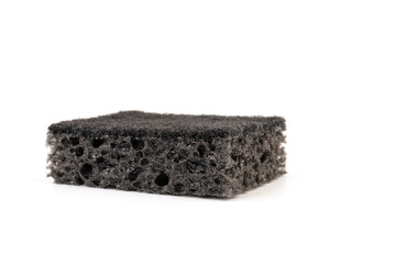 Black sponge used for washing dishes. Has two surfaces which are rough and smooth.