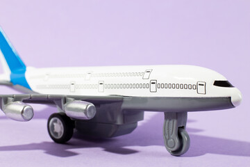 Close-up of toy airplane Object on a purple Background. Close up model plane airplane. Concept of travel holiday and business. minimal concept.