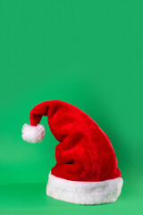 Santa Claus red hat isolated on green background. Happy new year concept, flatlay, copyspace.