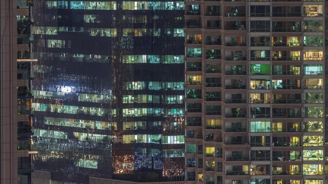 Windows of apartment and office buildings at night timelapse, the light from the windows of houses