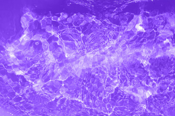 Defocus blurred transparent purple colored clear calm water surface texture with splashes and bubbles. Trendy abstract nature background. Water waves in sunlight with copy space. Purple water shining