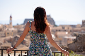 Concept city break. Rear view of woman looking at historic city, holiday concept.