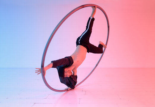 Acrobat doing trick with cyr wheel