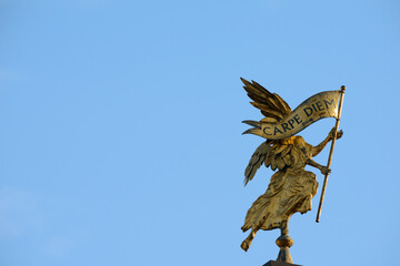 Golden angel carries a banner with the inscription: carpe diem