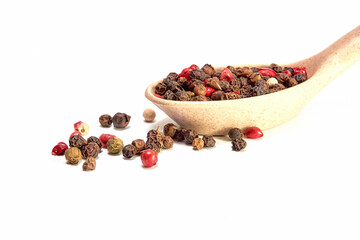Mixture of peppers in a wooden spoon on a white background, seasonings, spices, kitchen