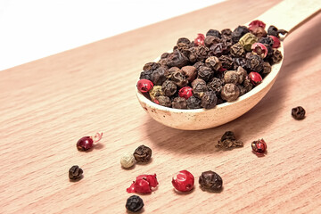 Mixture of peppers in a wooden spoon on a small cutting board, seasonings, spices, kitchen