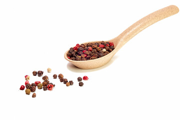 Mixture of peppers in a wooden spoon on a white background, seasonings, spices, kitchen