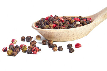Mix of peppers in wooden spoon and scattered balls of pepper close-up on white background, seasonings, spices, kitchen. Floating Focus
