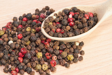 Mixture of peppers in a wooden spoon on a small cutting board, seasonings, spices, kitchen