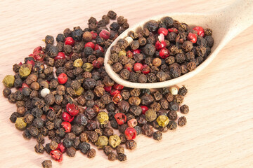 Mixture of peppers in a wooden spoon on a small cutting board, seasonings, spices, kitchen