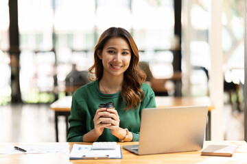 Asian woman working with laptop in her office. business financial concept.