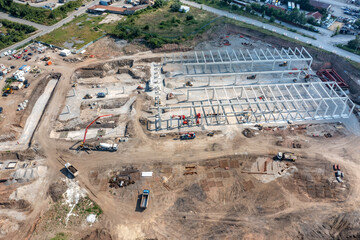 Aerial top view of huge construction site with many working heavy machines