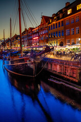 View of Nyhawn, the colorful houses next to the old port. Tourist visiting restaurants, cafes and...