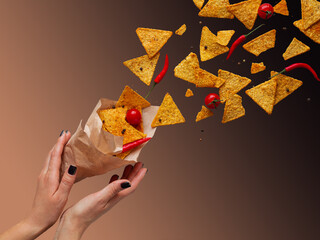 Flying crispy mexican nachos chips. Hands in the frame.