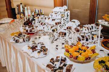 Buffet table with sliced ​​fruits and sweets.