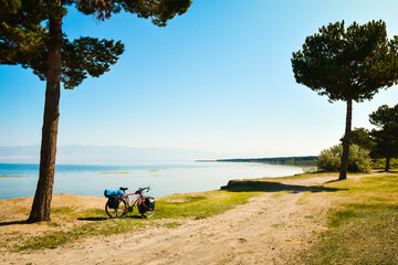 Close up touring bicycle stand on scenic nature countryside by sevan lake. Fully loaded touring machine with copy space background