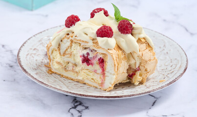 Baked meringue roll with cream and fresh red raspberry, white background.