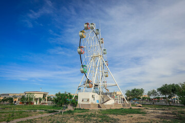 View to the Public Amusement Park with Ferris Wheel and White Rotunda in Urgench, Uzbekistan