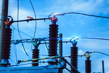 High voltage electric transformer.Electric current redistribution substation against the blue cloudy sky.Summer cloudy day.Toned.