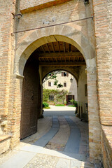Fototapeta na wymiar Montechiarugolo, Italy: entrance of the Castle, Castello of Montechiarugolo, Parma, Italy through the arches. Travel, tourism