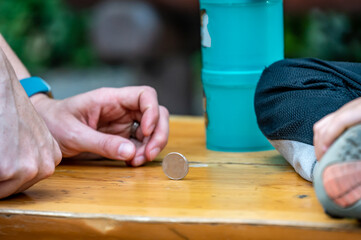 Two people playing a game with a spinning coin in order to pass time.