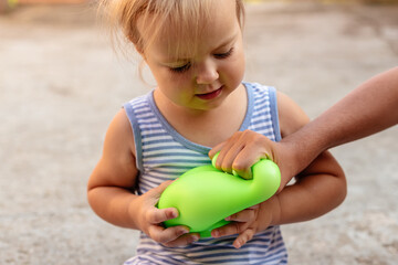 Little gir playing with anti stress sensory ball squeeze toy. Giant stress balls are soft to the touch and help reduce stress and anxiety as you pull, squish, smash, sensory toy