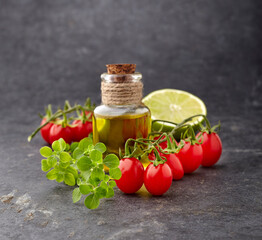 Tomatoes with  fresh thyme, lime  and olive oil on black background.