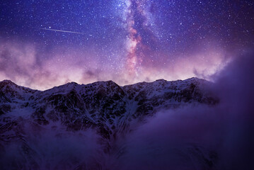 Beautiful fantasy night mountains landscape. Snow covered mountains under starry sky with bright milky way galaxy. 