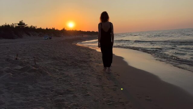 KOBIETA SPACERUJE BRZEGIEM MORZA. SAMOTNA KOBIETA SPACERUJĄCA NAD MORZEM.
KOBIETA SPACERUJĄCA PO MORSKIEJ PLAŻY.
