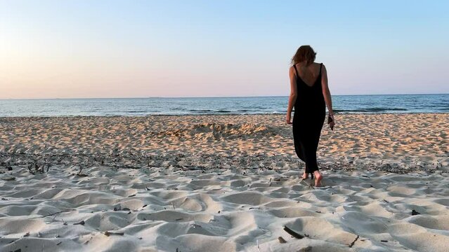 KOBIETA SPACERUJE BRZEGIEM MORZA. SAMOTNA KOBIETA SPACERUJĄCA NAD MORZEM.
KOBIETA SPACERUJĄCA PO MORSKIEJ PLAŻY.
