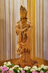 Vertical picture of the carved wood of the goddess Guan Yin.