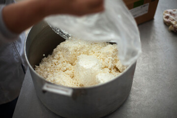 Cottage cheese in saucepan. Food in dining room. Cooking lunch in school kitchen. Dairy products. Chef's job.