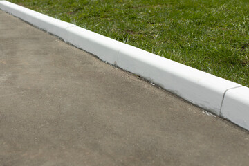 Painted curb. White curb on road. Landscaping in city. - obrazy, fototapety, plakaty