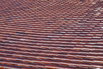 Close-up to texture of brown tile on the roof.